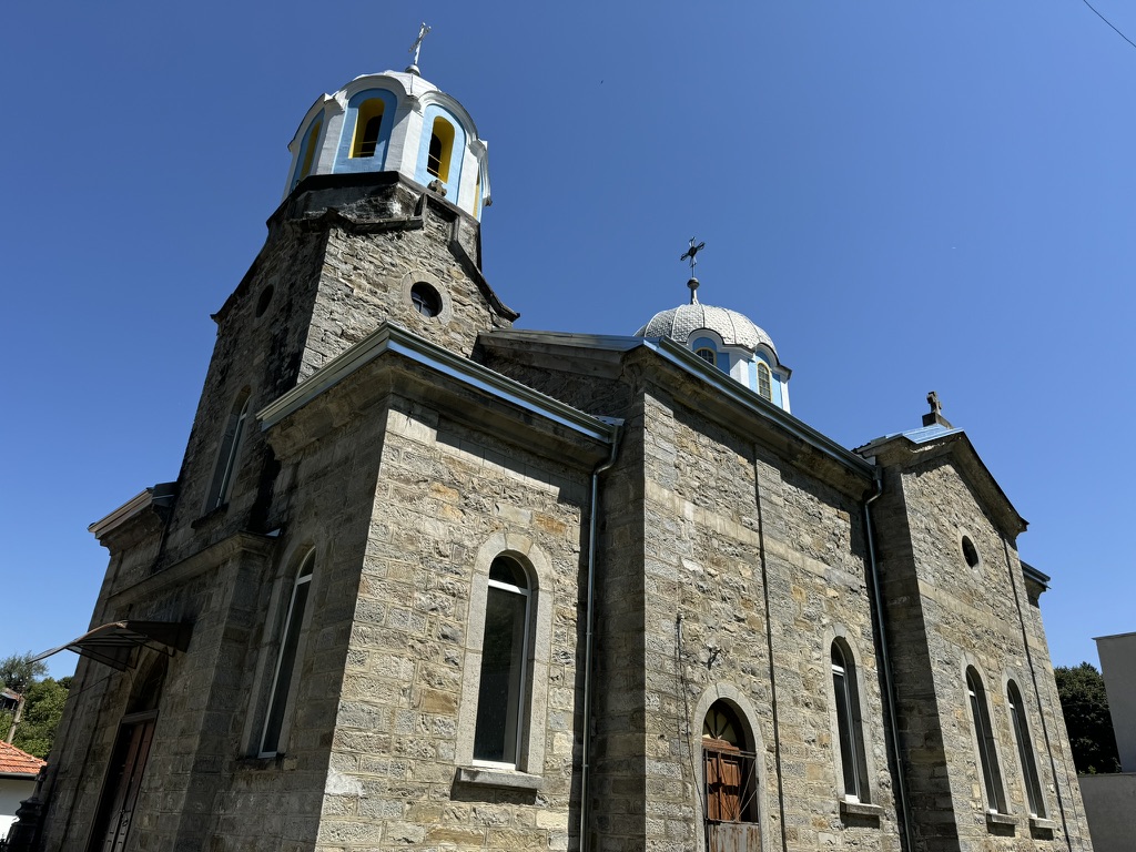 Каменната фасада и камбанарията на храма, гледани отдолу